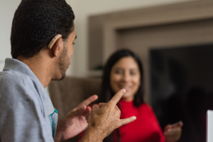 A deaf person exchanging with a colleague in sign language