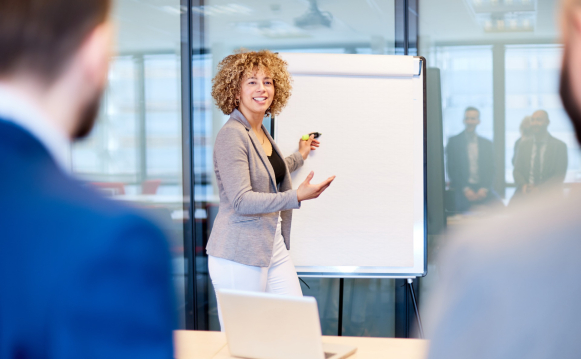 A woman standing in front of a board during a training session