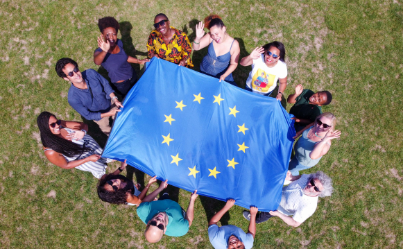 Aerial view of a group of people holding an EU flag