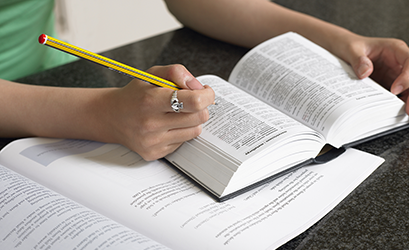 Picture of woman's hands and a pen with a book