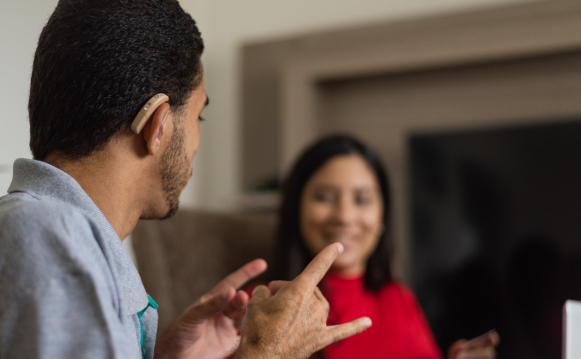 A deaf person exchanging with a colleague in sign language