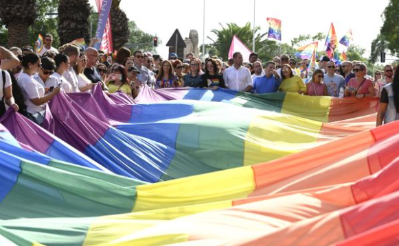 people keeping a rainbow flag